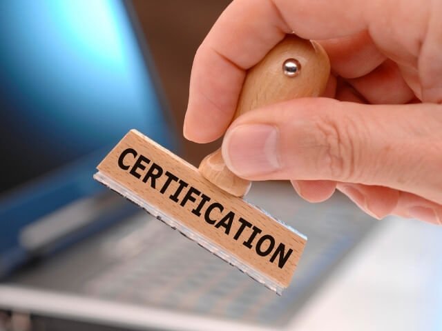 mão segurando um carimbo escrito certification