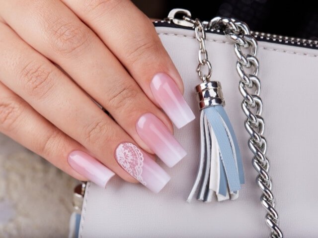 Mão feminina exibindo unhas feitas por sua nail designer.
