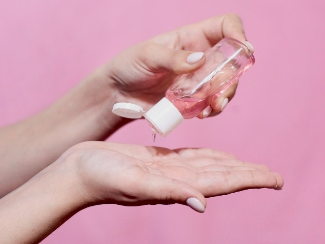 mãos femininas com um vidro de Shampoo de bebê indicado para lavar sobrancelhas sem agredir