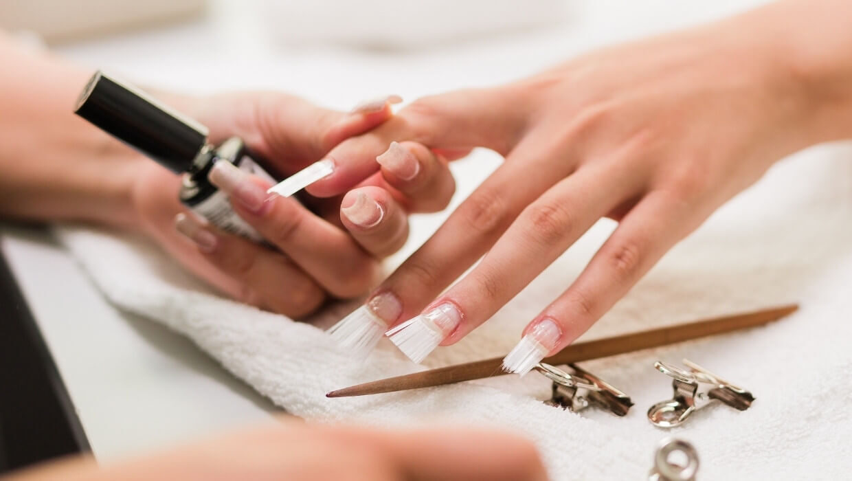 Unhas em fibra de vidro sendo colocadas por uma profissional